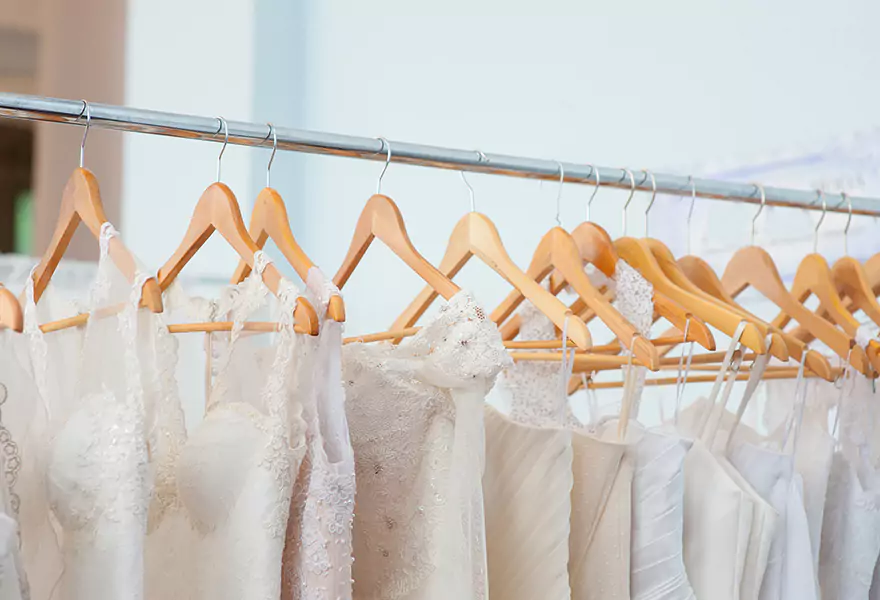 Viele weiße Brautkleider hängen auf einer Kleiderstange
