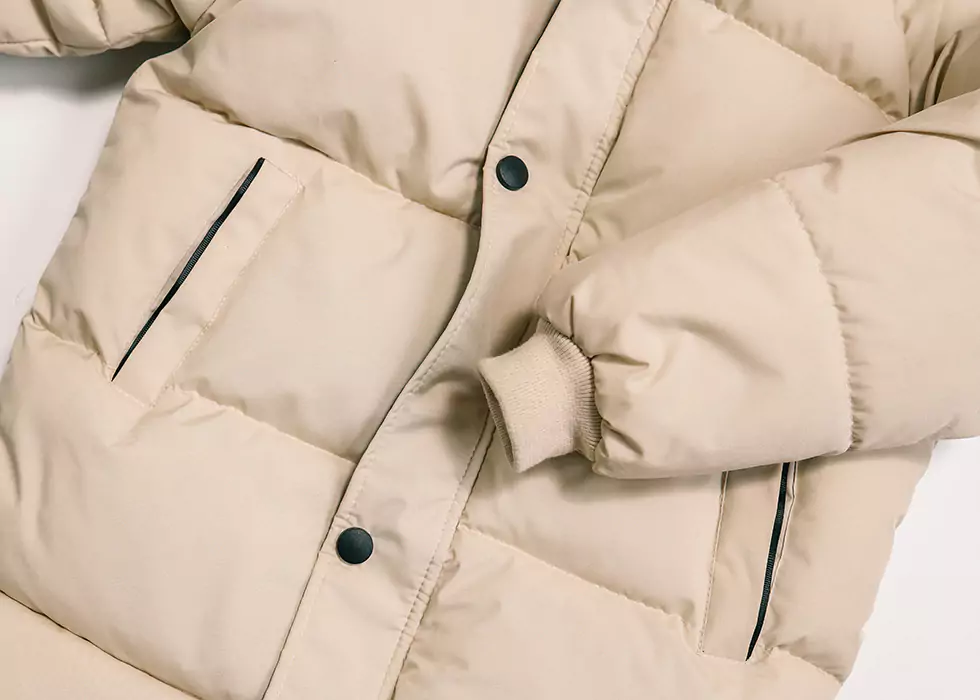 Moderne beige Damen Daunenjacke mit schwarzen Knöpfen